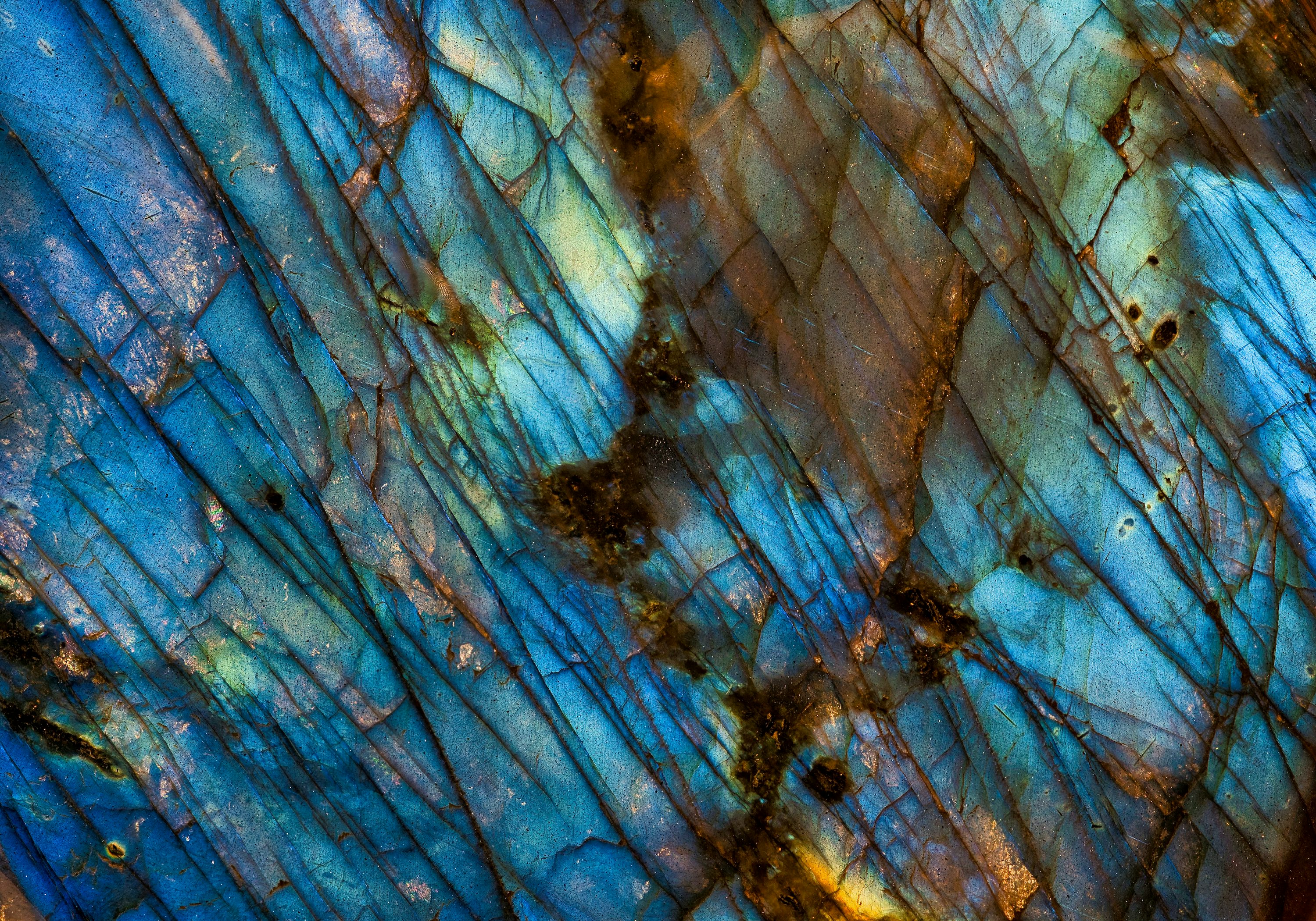 Texture de pierre ou de pierre précieuse bleu-vert avec veines et reflets irisés, motifs en diagonale et taches sombres.