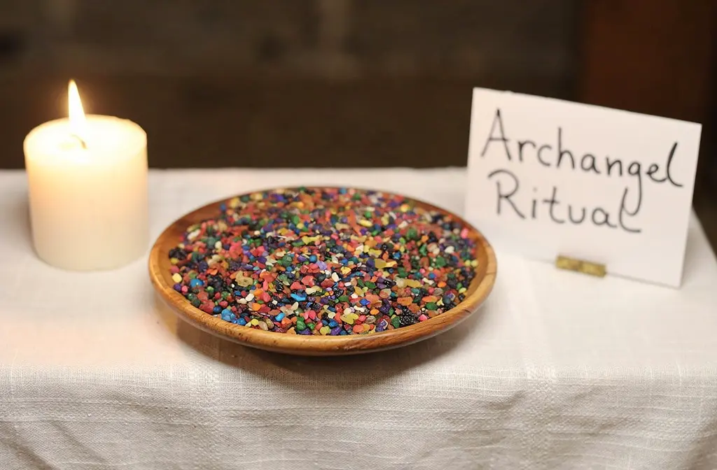 Bol en bois rempli de grains de résine colorés sur un autel spirituel pour invoquer un archange.