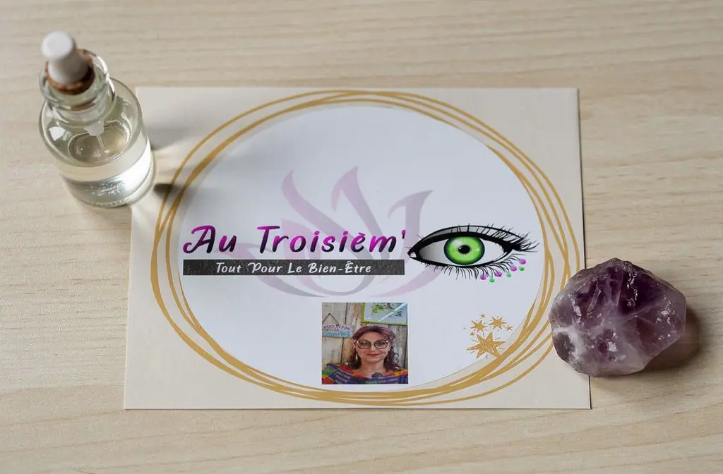 Logo Au Troisièm'bien-être posé sur un bureau en bois avec un élixir de cristal et une pierre d'améthyste.